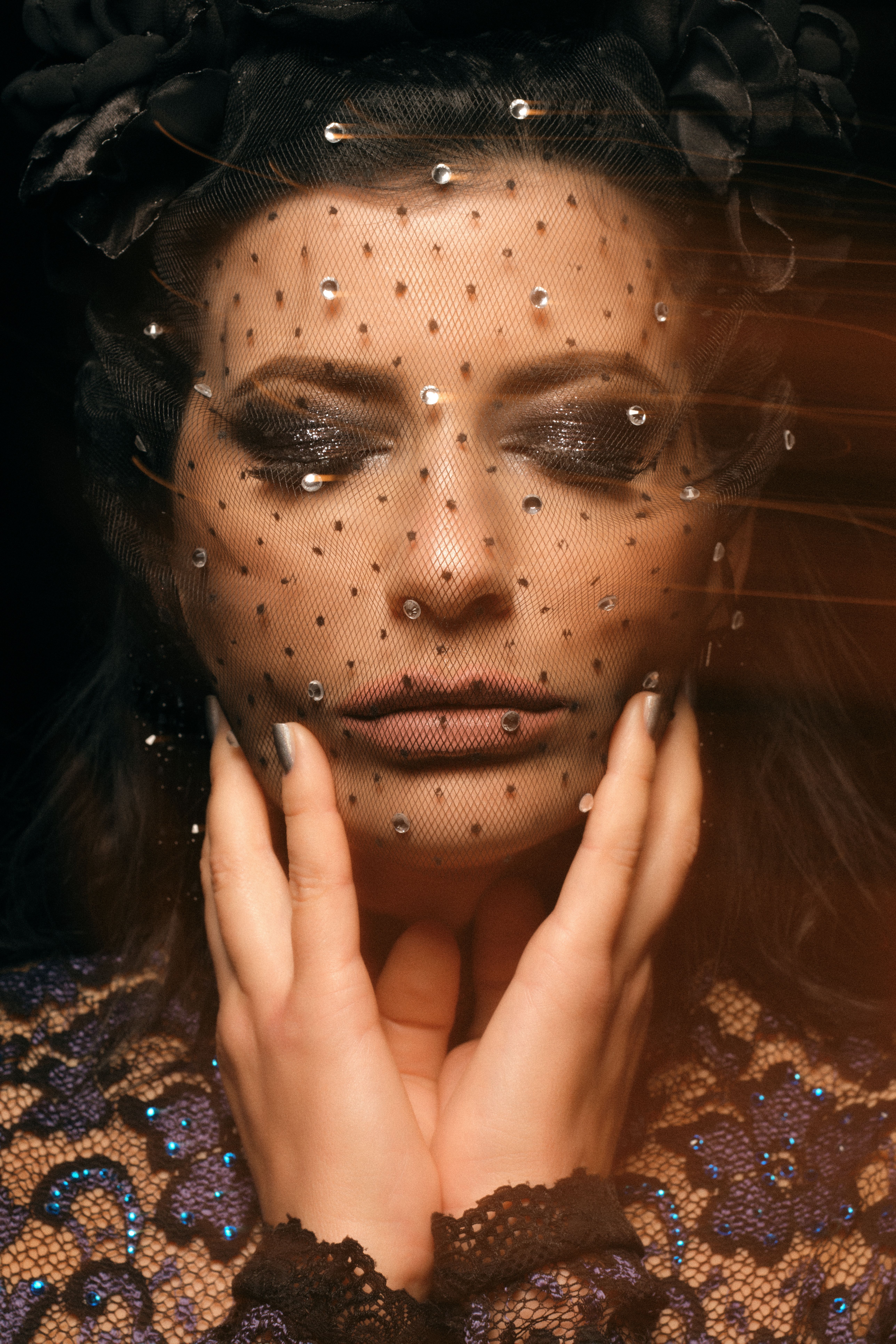 Editorial portrait of a model wearing a jeweled veil